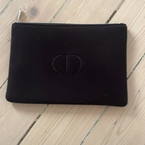 Svart nesesär från Christian dior - Säljer en svart nesesär från Christian dior med diskret CD-logo på framsidan och silverfärgad dragkedja med Dior-gravyr.