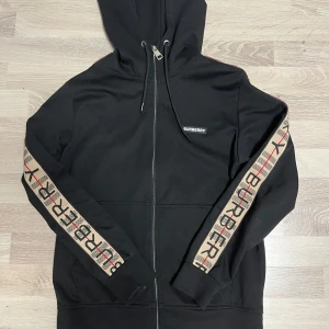 Burberry zip hoodie - Stilig zip tröja från burberry i storlek S, inga synliga skador förutom en skada vid dragkedjan men enkelt att fixa.