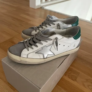 Golden goose skor  - Golden goose skor i strl 40 men passar mycket större ca 41,5-42. Väldigt bra skick men heeldrag finns men inget som påverkar alls .Allt og ingår (box, Golden goose passport, dustbag) Online kvitto finns samt äkthets certifikat. Priset är ej fast!
