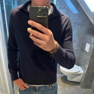 Mörkblå stickad tröja från Ströms - Riktigt schysst långärmad piké från Ströms. Perfekt nu till hösten.  Är 188cm men tröjan är för kort på mig så rekommenderar att man e lite kortare än så. Nypris köptes den för 1999kr