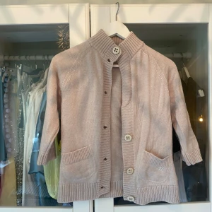 Kortärmad kofta  - Beige kofta med trekvarts ärmar och knappt. Saknar en knapp i fram. 