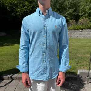 Blå Ralph Lauren Skjorta - Ljusblå Ralph lauren skjorta || Storlek S (Slim Fit) || Skjorta är i bra skick || Mitt pris 599kr || Modellen på bilden är 170cm och väger 62kg || Tveka inte på att höra av dig vid frågor eller funderingar 