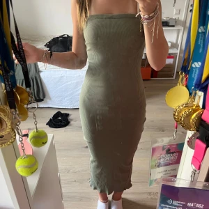 Grön ribbad långklänning strl S - Säljer en snygg grön ribbad långklänning i storlek S. Klänningen är armlös med en slits på ena sidan och har en tight passform. Materialet är mjukt och stretchigt! 💗