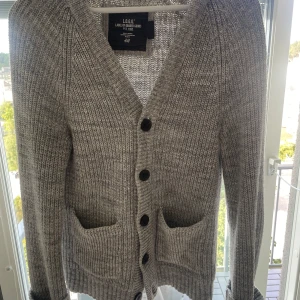 Grå stickad cardigan från H&M - Säljer en tvär fet stickad cardigan från hm. Den är väldigt trendig och perfekt för sommar kväller och hösten. Cardiganen bär storleken s. Vid fler frågor och funderingar är de bara att höra av sig