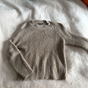 Beige stickad tröja från 157 - Säljer en beige stickad tröja från 157 i storlek S. Tröjan har ett grovt, ribbat mönster och rund halsringning. Långa ärmar och mjukt material som känns chill och passar perfekt när det är lite kallare ute. Enkel och snygg att matcha med jeans eller kjol.