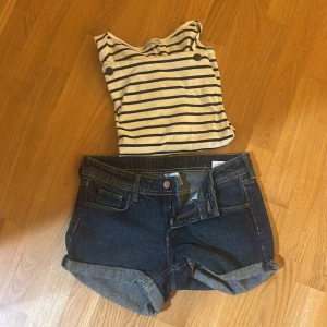 Randig linnetopp från Zara - Säljer en vit och marinblå randig linnetopp från Zara. Toppen är ärmlös med breda axelband och har en klassisk båtringning. Perfekt för sommardagar och enkel att matcha med jeansshorts eller kjol.