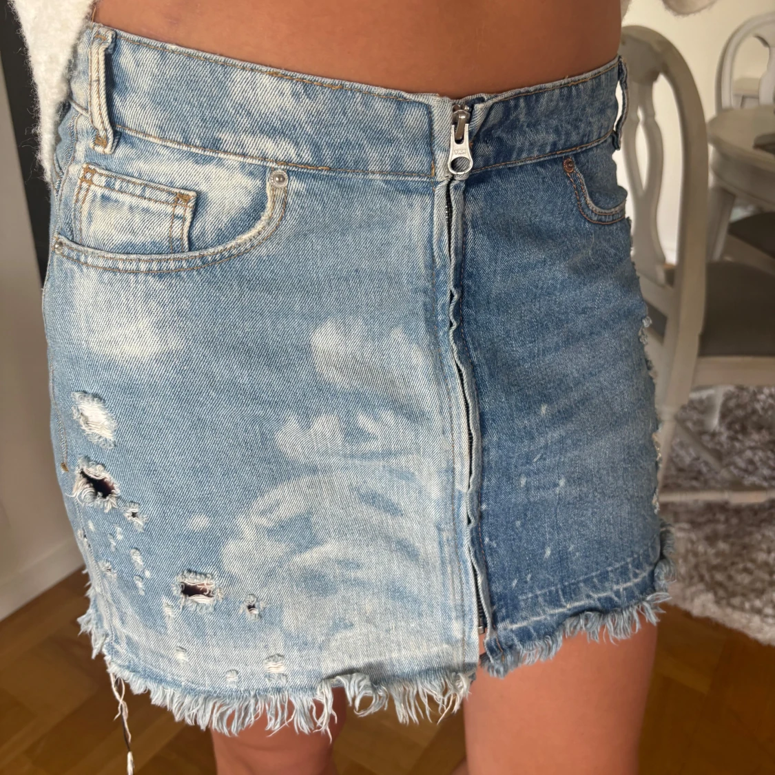 Blå jeanskjol med slitningar