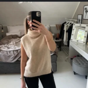 Beige stickad väst med polokrage - Säljer en beige stickad väst med hög polokrage. Västen är ärmlös. Den är i jätte bra skick (första bilden är lånad) 