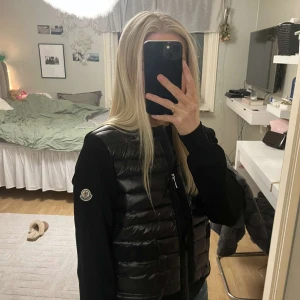 Svart dunväst från Moncler - Säljer ny Syrrans fina Moncler Cardigan då den inte används längre. Storleken är 2/M men  passar även S. Tveka inte på att höra av dig vid frågor Mvh. Mått👇🏼👇🏼👇🏼 📏 Ärmlängd: 58 cm 📏 Längd (axel till midja): 53 cm 📏 Midja: 41 cm 📏 Bröst: 45 cm