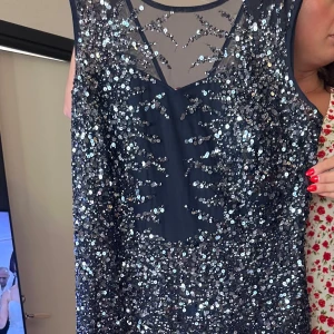 Marinblå paljettklänning med mesh - Säljer en marinblå långklänning med massor av glittriga paljetter och snygg meshdetalj upptill. Klänningen är ärmlös och har en v-ringad hals. Perfekt för dig som vill sticka ut och glänsa på nästa bal eller fest!