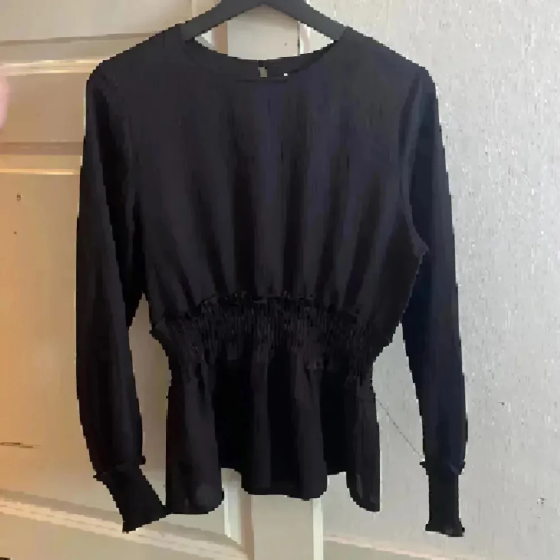 Svart blus med smockad midja