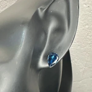 Eleganta droppformade vintageörhängen med blå kristall 80-tal 90-tal  -  Vackra vintageörhängen från 80/90-tal i droppform med mörkblå, facettslipade glasstenar infattade i silvrig metall. Ca 0,5 cm långa. I fint skick, sannolikt bijouteri. Säljs eftersom jag inte använder dem längre.  Priset är redan lågt – jag prutar inte, men erbjuder bra rabatt vid köp av flera saker. Jag rensar smyckesskrin och garderob, så kika gärna in på mina andra annonser också!  