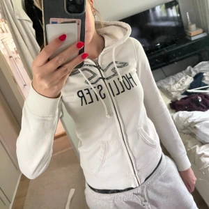 Vit hoodie från Hollister med paljetter - Säljer en vit hoodie från Hollister i storlek S. Perfekt för chill dagar och snygg till jeans eller mjukisbyxor💕💕💕