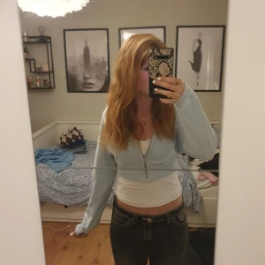 Ljusblå croppad hoodie med dragkedja - Säljer en ljusblå croppad hoodie med huva och dragkedja framtill. Tröjan har långa ärmar, ribbad nederkant. Supermjuk och skön att ha på sig! Säljes då den inte kommer till användning!