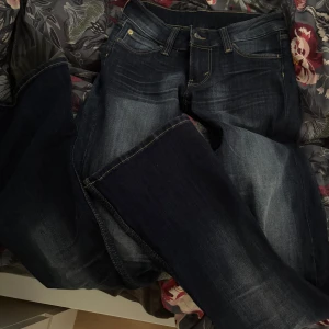 Mörkblå jeans från Cheap Monday - Säljer ett par snygga mörkblå jeans från Cheap Monday med klassisk femficksdesign och cool orange patch bak. Aldrig använda, säljer för att jag inte hann lämna tillbaka i tid.