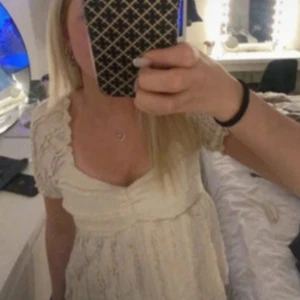 Söt vit blus  med spetsdetaljer - Supersöt vit blus  med romantiska spetsdetaljer och volang vid ärmarna. Toppen  har v-ringning och korta ärmar, perfekt för sommarens alla tillfällen. Lätt och luftig känsla, passar dig som gillar en feminin och trendig stil.