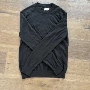 Svart långärmad tröja These glory days - En stilren svart långärmad tröja från These glory days Tröjan har rund halsringning och är gjord i mjuk merinoull, perfekt för lager-på-lager eller som den är. Enkel och clean look som passar till allt. Hör av dig vid fundering 👍