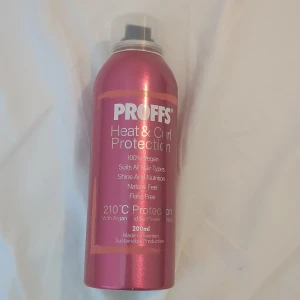 PROFFS Heat & Curl Protection spray - Säljer en rosa värmeskyddsspray från PROFFS, perfekt för dig som stylar håret med värmeverktyg. Sprayen är vegansk, ger glans och näring, och skyddar upp till 210°C. Innehåller argan- och solrosextrakt. Flaskan rymmer 200 ml.