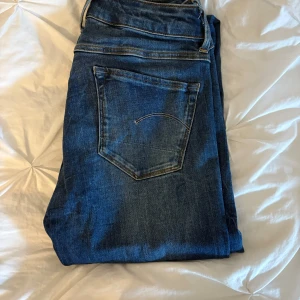 G-star Raw - Tajta jeans med låg midja från G-star Raw. Sjukt snygga med ett par höga boots till. Dessa är i en mörkare tvätt som passar super till allt. Storleken är 25 i midjan och 32 i längden. Kom privat för funderingar eller fler bilder🙏😁💕
