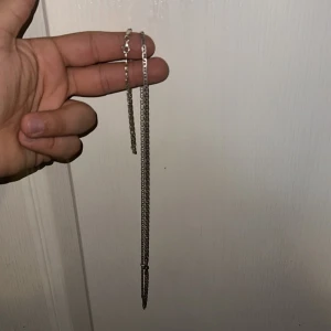 Kedjehalsband i silverfärg - Säljer ett stilrent silver 925 halsband . Halsbandet har en enkel karbinhake och passar perfekt för dig som gillar minimalistiska smycken. Länkarna är platta och ger ett snyggt intryck. Perfekt accessoar för att lyfta din outfit.