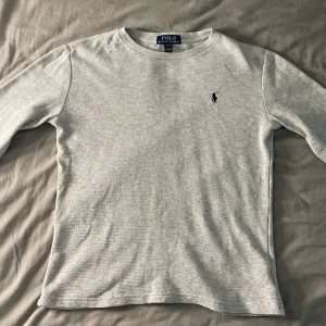 Grå Sweatshirt från Polo Ralph Lauren - Säljer en grå sweatshirt från Polo Ralph Lauren. Tröjan är i väldigt fint skick. Men dock relativt liten. Storlek M (10-12) (Ungefär stl. 150)  Mått 📏📐 - Bröstvidd 43cm  - Bottenvidd 41cm - Plagglängd 53cm - Armlängd 42cm  Hör gärna av er vid frågor  ~ LoopSupply ~