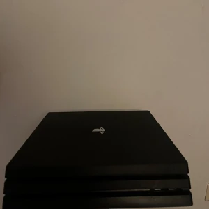 Svart ps4 PRO, sladdar ingår  - Bilderna visar en svart PlayStation 4 Pro-konsol, inte en bok. Ingen information om boktitel, författare eller innehåll kan identifieras från dessa bilder.