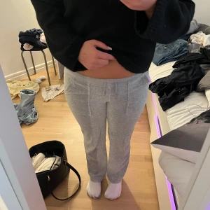 Grå mjukisbyxor från Juicy Couture - Säljer ett par grå mjukisbyxor från Juicy Couture i storlek S. Byxorna har dragsko i midjan, raka ben och snygga fickor med lock och silverfärgade knappar bak. Säljer då dem är för små för mig.💞