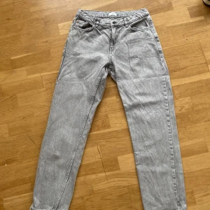 Grå jeans från Grunt i rak modell - Snygga grå jeans från Grunt med klassisk femficksdesign och raka ben. Jeansen har normal midja och är tillverkade i bomullstyg med en ljusgrå tvätt. Perfekta för en clean och avslappnad look.