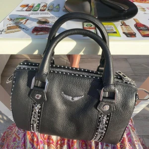 Zadig & Voltaire  - Säljer nu min superfina Zadig & Voltaire väska. Helt ny, men sitter inte kvar någon prislapp på eftersom jag använt den 2 gånger. Säljer pga att det finns annat jag är intresserad utav att köpa istället. Inga defekter eller liknande. Som ny 💞 Den är självklart äkta. Kvittot, äkthetsbevis samt dustbag finns och skickas även med vid köp. Viss prutmån finns, men inga orimliga bud. Köpt för 5100kr. Hör gärna av er 💞