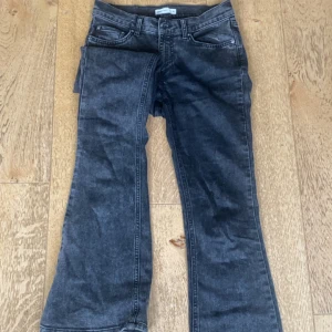 Svarta bootcut jeans - Snygga svarta jeans med bootcut-modell och klassisk femficksdesign. Jeansen har en mörk tvätt och raka ben som blir vidare nedtill. Perfekta för dig som gillar en retroinspirerad look. Enkla och stilrena fickor på baksidan utan några detaljer eller knappar.