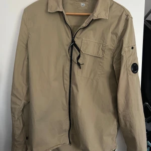 C.P Company overshirt  - Beige overshirt från C.P Company. Använd ett fåtal gånger. Inga hål, fläckar eller något sådant. Självklart äkta. 
