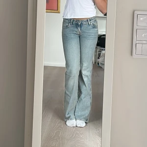 Ljusblå bootcut jeans från Gina  - Säljer ett par ljusblå lågmidjade jeans från Gina med bootcut passform. Jeansen har knappar på bakfickorna. Byxorna är använda men i bra skick. Är i storlek 36, jag är 1.70m 