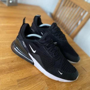 Nike Air Max 270 Storlek 44 - Svarta Nike Air Max 270 som sitter fint på både damer och herrar. Säljes för 450kr.  (Lite smutsiga på bilden). Svart bubbla och tyg med själva sulan som är vit och undersidan rosa. Det finns synliga slitage och tecken på användning. Pris kan diskuteras, endast serösa köpare! Tack 😊