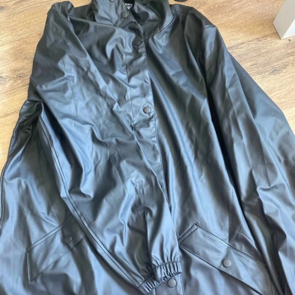 Svart regnjacka med huva - 1