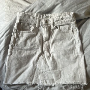 Vit jeanskjol från g perfect jeans - Vit jeanskjol med rå kant nertill och klassiska femficksdetaljer. Kjolen har bälteshällor, knapp och dragkedja framtill samt bakfickor. Perfekt för en chill och trendig look.