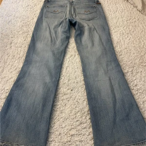 Lågmidjade bootcut jeans - Snygga ljusblå lågmidjade jeans från Moto med bootcut passform och klassisk femficksdesign.Lite slitningar längst ner . Midjemått : 40cm Innerbenslängd :  77 cm