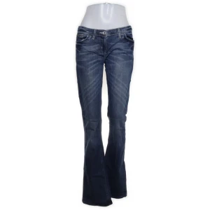 Mörkblå bootcut jeans  - Snygga mörkblå jeans med klassisk bootcut-passform. Jeansen har fyra fickor, snygga slitningar och kontrastsömmar. 