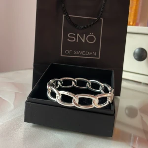 Silverfärgat armband från Snö of Sweden - Stilrent armband i silverfärg från Snö of Sweden med stora, ovala länkar. Perfekt accessoar för att lyfta din outfit med en modern och trendig touch. Kommer i original ask och påse. Aldrig använd