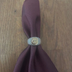 Silverring med tigerhuvud i guld, säljs idag - Cool signetring i silver med ett detaljerat lejonhuvud i guld på ovansidan. Ringen har snygga ingraverade detaljer längs kanterna och är tillverkad i 925 sterling silver. Perfekt statement-piece för dig som vill sticka ut. Nypris 2079kr