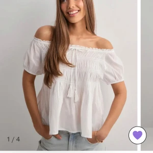 Vit offshoulder blus med knyt - Superfin vit blus från Nelly med offshoulder och korta puffärmar. Luftig och lätt i bomull, perfekt för varma dagar. Den är helt oanvänd med lappen kvar. Priset kan diskuteras vid snabbt köp💕