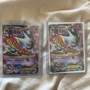 Pokémon Mega Gengar EX - Värde 800kr var. Två coola Mega Gengar EX Pokémonkort med färgstark design och holoeffekt. Perfekt för samlare och fans av Pokémon TCG! Korten är i bra skick och levereras i skyddande plastfickor. Ett måste för dig som vill utöka din samling med en av de mest ikoniska spökpokémon.