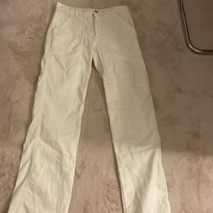 Vita Jeens från Zara, strl 36 - Klassiska vita byxor från Zara i rak modell med normal passform. Byxorna har fickor fram och bak, bälteshällor och stängs med knapp och dragkedja. Perfekta till en clean och stilren look.