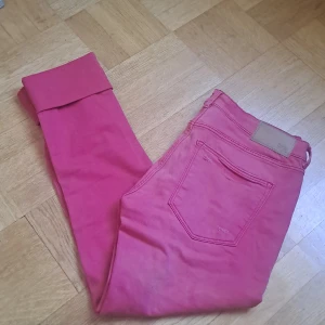 Röda jeans   - Snygga röda jeans från Divided by H&M i storlek 42. Klassisk femficksmodell med knapp och dragkedja framtill. Jeansen har raka ben och är tillverkade i bomull med en skön passform. 🩷