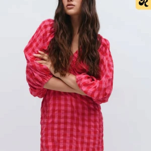 Rutig röd kortklänning från Gina Tricot - Superfin röd kortklänning med rutigt mönster och v-ringning från Gina Tricot. Klänningen har ballongärmar med resår vid ärmslut och en loose passform. Perfekt för dig som vill sticka ut med färg och mönster.