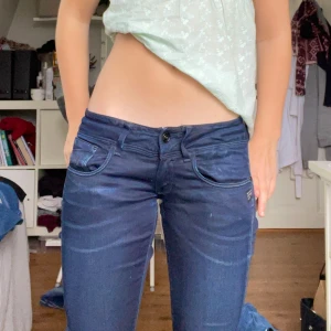 Mörkblå lågmidjade bootcut jeans  - Säljer dessa mörkblå jeans som jag har sytt om till bootcut. Jag har även sytt in resår i midjan då jeasen var för stora för mig. Så midjemåttet går att stretcha ut från 34 tvärs över midjan till 39 cm. Innerbenslängden 79 cm. Kontakta mig privat vid frågor eller liknande🩷