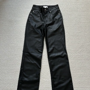 Svarta skinnbyxor - Snygga svarta skinnbyxor från hm med hög midja och raka ben. 