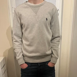 Ralph Lauren sweatshirt - Säljer en stilren autentisk grå tröja från Ralph Lauren köpt från deras officiella hemsida för 2000 kr. Tröjan är i nytt skick och har inga defekter. Modellen är cirka 177 cm lång. Hör av er vid frågor! 🤙🏼 