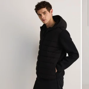 Svart hybridjacka/cardigan - Snygg svart hybridjacka/cardigan med huva och dragkedja framtill. Perfekt för våren. Cardiganen har en stilren design och passar bra till olika outfits. Passar S men även i mindre M eftersom den är lite bred i magen. Priset är ej hugget i sten! Tveka inte att skriva i dm om ni har funderingar.