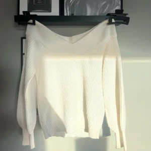 Vit stickad offshoulder tröja - Säljer en vit stickad offshoulder tröja med långa ärmar.