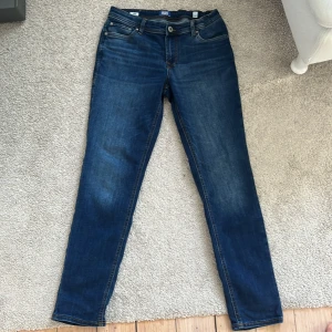 Blå slim jeans från Jack & Jones - Snygga blå slim jeans från Jack. & Jones i storlek 164. De har en klassisk femficksdesign och en bekväm passform. Perfekta för en stilren look.